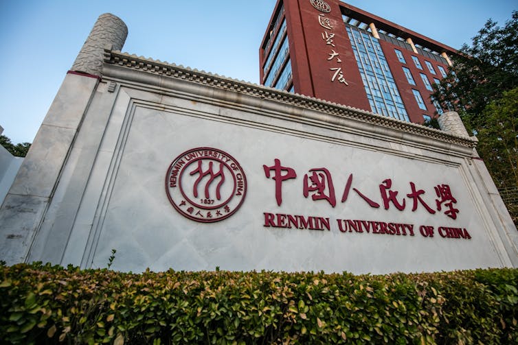 A hedge-lined entrance to a university campus.